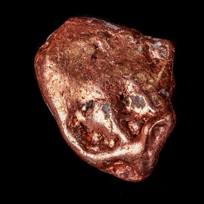 Macro mineral stone of a copper nugget on a microcline on a black background close up